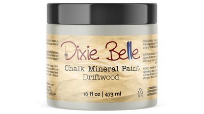 A jar of Dixie Belle Chalk Mineral Paint in the Driftwood scent, featuring a textured beige label and a black lid on a white background.