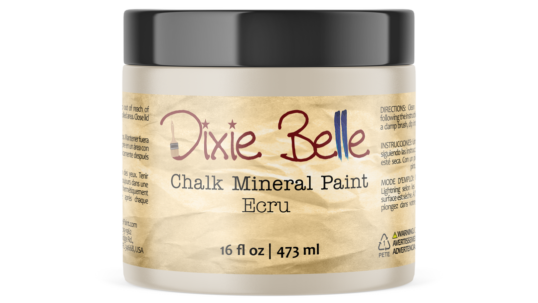 A jar of Dixie Belle Chalk Mineral Paint in the color Ecru, featuring a black lid and a textured tan paper label, shown on a clean white background.