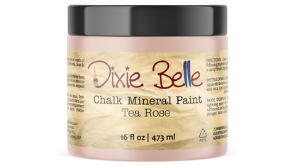 A jar of Dixie Belle Chalk Mineral Paint in the Tea Rose color, featuring a black lid and a beige textured label, shown against a plain white background.