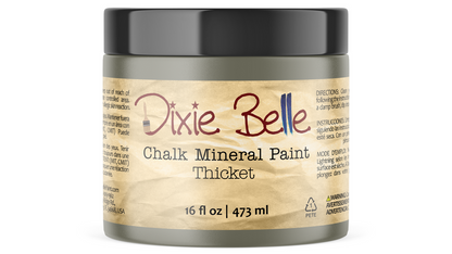 A jar of Dixie Belle Chalk Mineral Paint Thicket, 16 fl oz, featuring a textured beige label and a black lid on a white background.