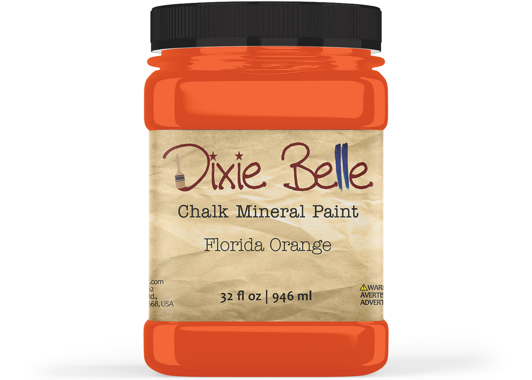 A jar of Dixie Belle Chalk Mineral Paint in the color Florida Orange, featuring a black lid and a beige textured label, shown on a white background.