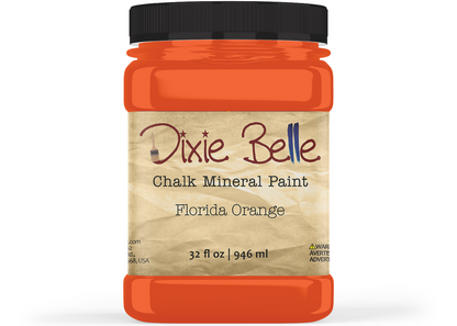 A jar of Dixie Belle Chalk Mineral Paint in the color Florida Orange, featuring a black lid and a beige textured label, shown on a white background.