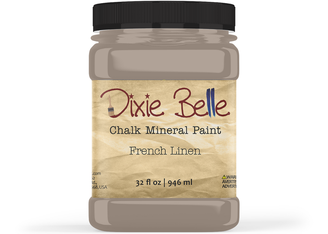 A jar of Dixie Belle Chalk Mineral Paint in the color 'French Linen', featuring a black lid and a textured beige label, shown on a white background.