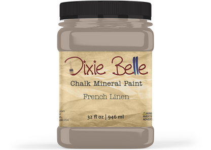 A jar of Dixie Belle Chalk Mineral Paint in the color 'French Linen', featuring a black lid and a textured beige label, shown on a white background.