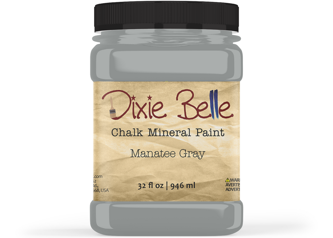 A jar of Dixie Belle Chalk Mineral Paint in the shade Manatee Gray, featuring a black lid and a textured tan label, shown on a white background.