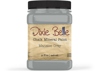 A jar of Dixie Belle Chalk Mineral Paint in the shade Manatee Gray, featuring a black lid and a textured tan label, shown on a white background.