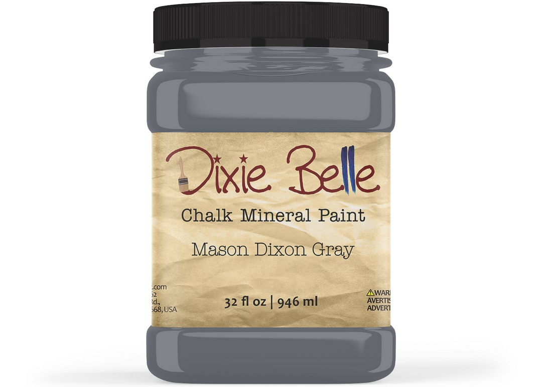 A jar of Dixie Belle Chalk Mineral Paint in the color Mason Dixon Grey, featuring a black lid and a beige label on a white background.