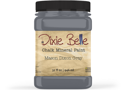 A jar of Dixie Belle Chalk Mineral Paint in the color Mason Dixon Grey, featuring a black lid and a beige label on a white background.