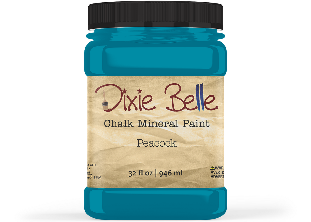 A jar of Dixie Belle Chalk Mineral Paint in the color Peacock, featuring a black lid and a beige textured label, shown on a white background.