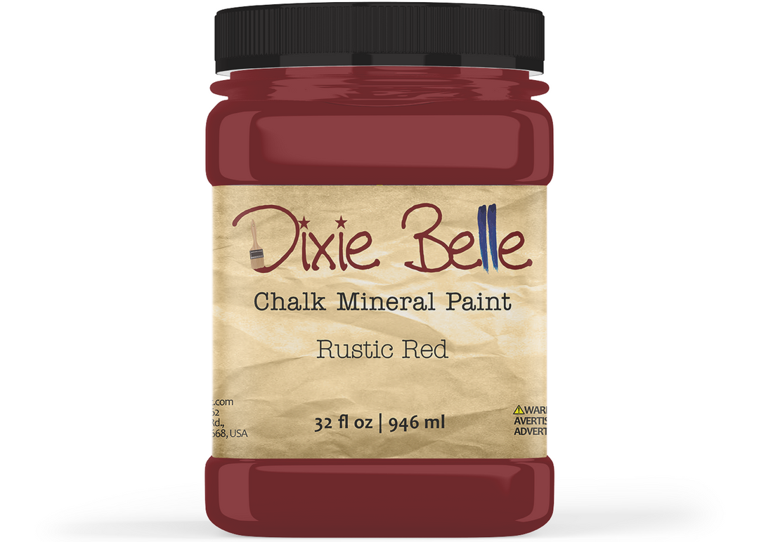 A jar of Dixie Belle Chalk Mineral Paint in the color Rustic Red, featuring a black lid and a beige textured label, shown on a white background.