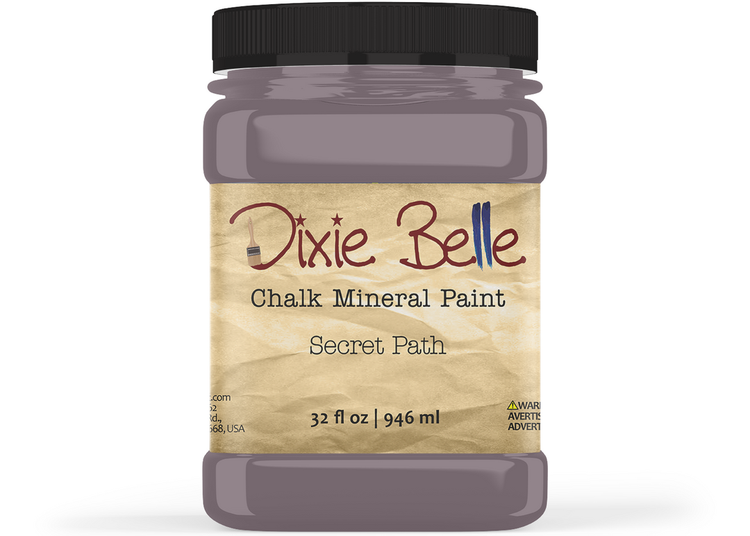 A jar of Dixie Belle Chalk Mineral Paint in the color 'Secret Path', featuring a black lid and a beige textured label, shown on a white background.