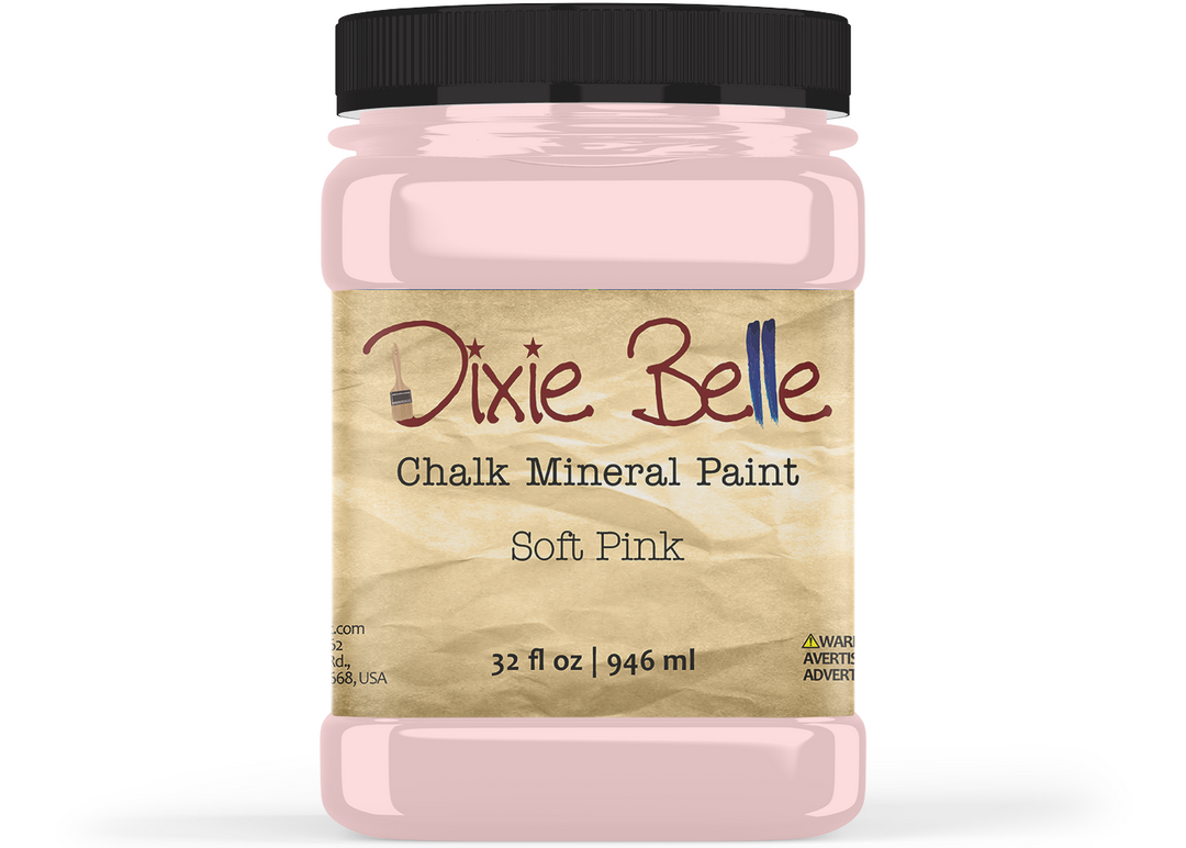 A jar of Dixie Belle Chalk Mineral Paint in the color Soft Pink, featuring a black lid and a beige textured label.
