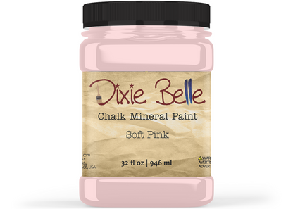 A jar of Dixie Belle Chalk Mineral Paint in the color Soft Pink, featuring a black lid and a beige textured label.