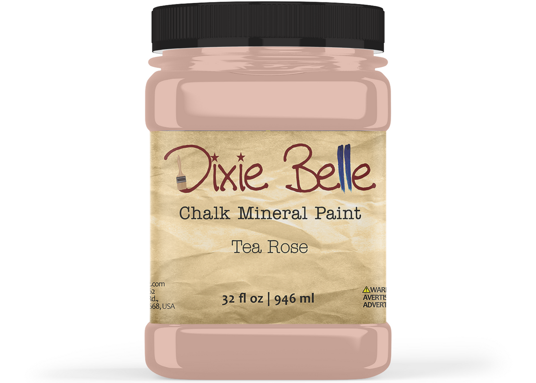 A jar of Dixie Belle Chalk Mineral Paint in the Tea Rose color, featuring a black lid and a textured beige label, shown on a white background.