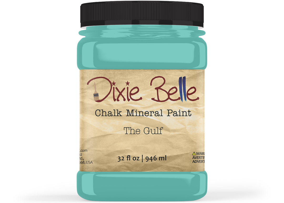 A jar of Dixie Belle Chalk Mineral Paint in the shade 'The Gulf', featuring a black lid and a tan label, shown on a white background.