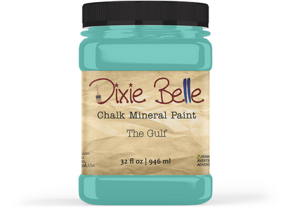 A jar of Dixie Belle Chalk Mineral Paint in the shade 'The Gulf', featuring a black lid and a tan label, shown on a white background.