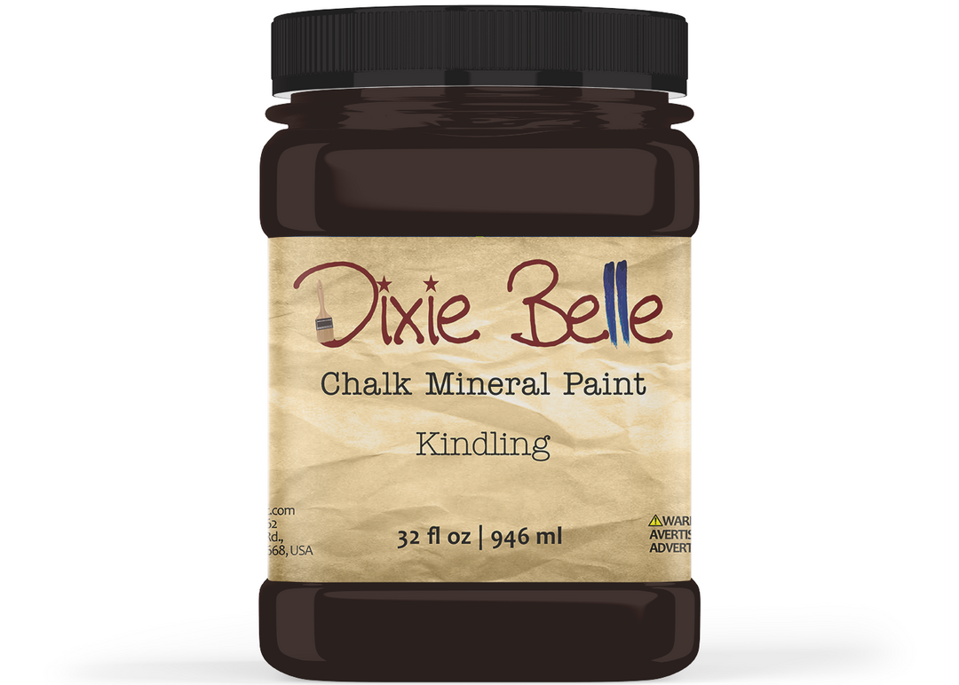 A jar of Dixie Belle Chalk Mineral Paint in the color 'Kindling', featuring a black plastic jar and a textured beige label with brown and blue lettering.