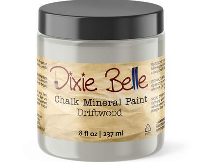 A jar of Dixie Belle Chalk Mineral Paint in the color Driftwood, featuring a black lid and a beige label with the brand name in red script.
