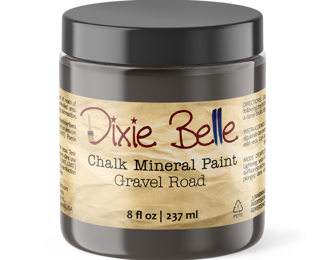 A jar of Dixie Belle Chalk Mineral Paint in the color Gravel Road, featuring a black lid and a beige label with red and blue lettering.