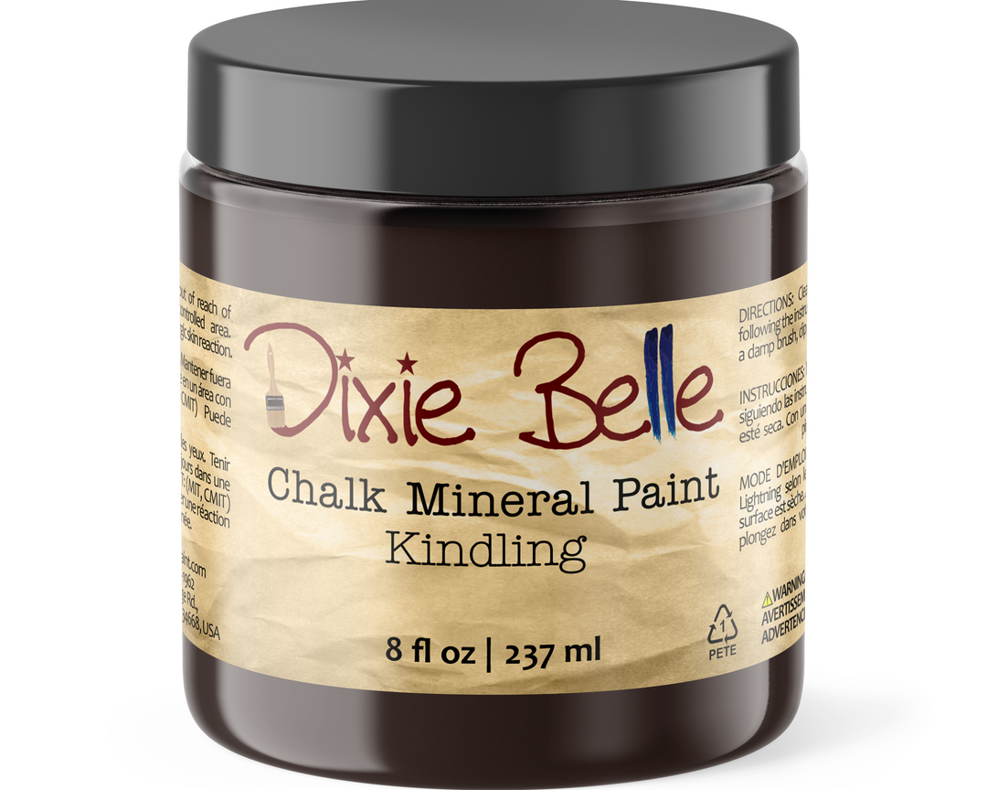 A jar of Dixie Belle Chalk Mineral Paint in the color 'Kindling' with an 8 fl oz capacity. The product is housed in a dark brown translucent plastic jar with a black screw-on lid and a textured tan paper-style label.