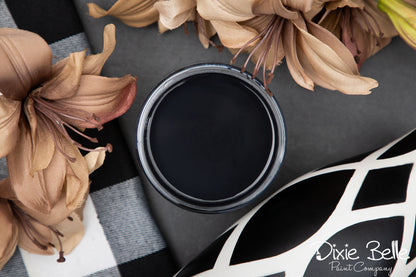 Black paint can with flowers on a checkered fabric background