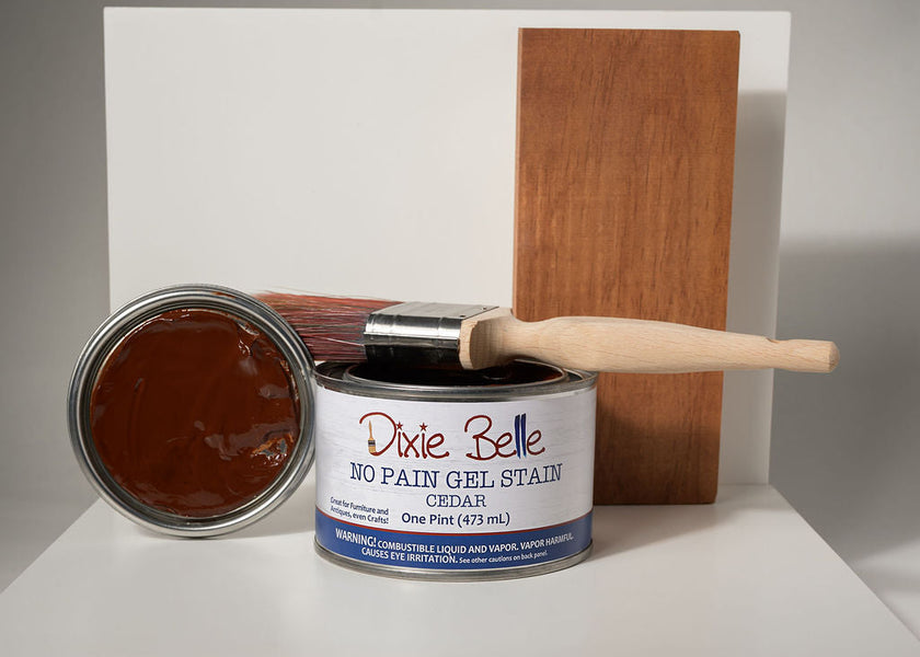Can of Dixie Belle No Pain Gel Stain with a brush and wooden board on a white background
