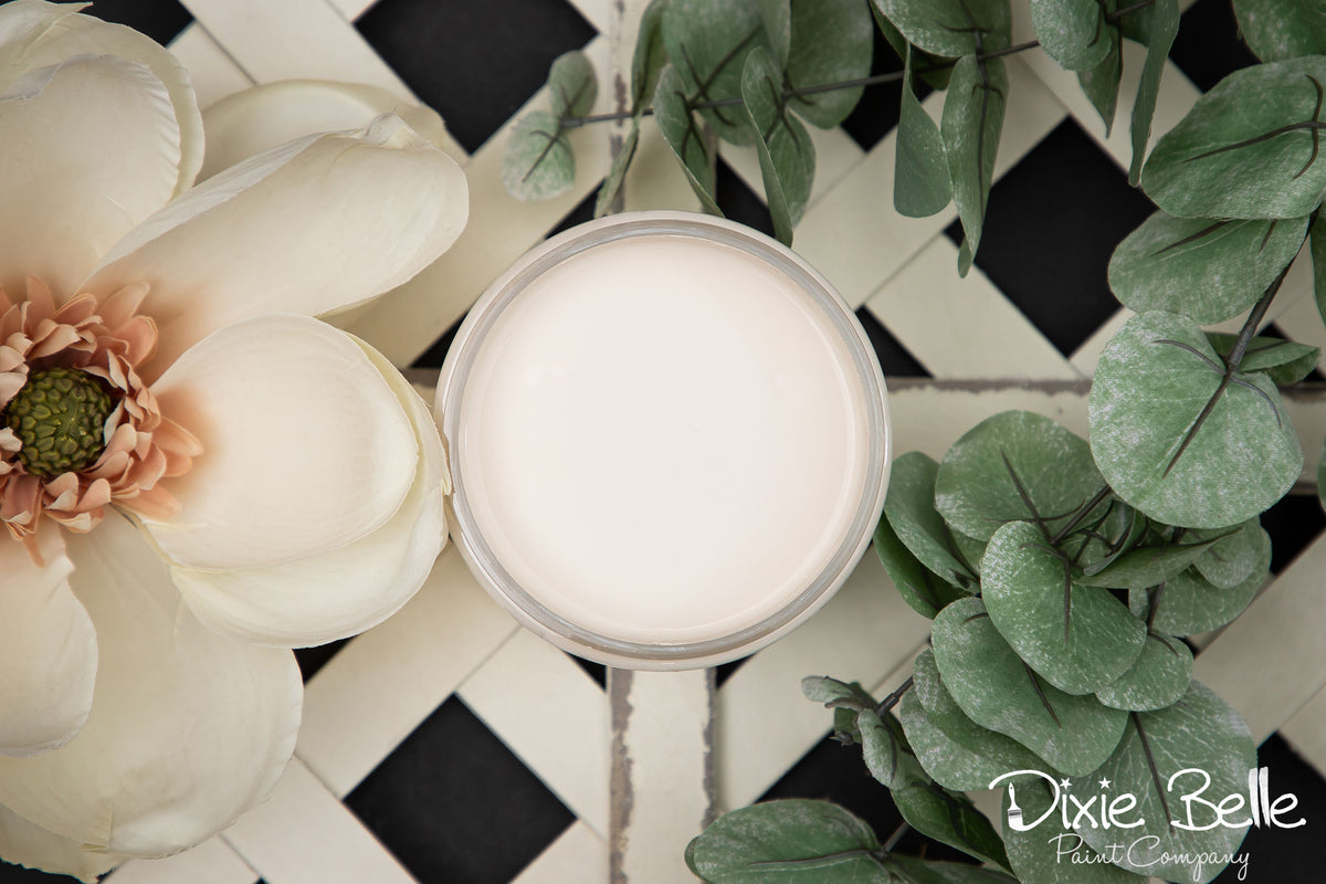 drop cloth paint product with flowers and greenery on a checkered surface, featuring the brand 'Dixie Belle'.