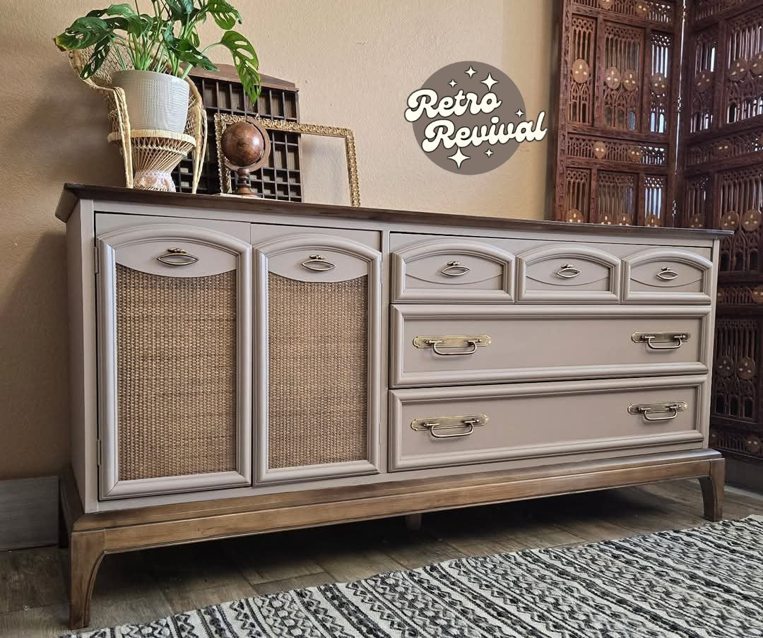 A vintage-style wooden storage cabinet with a distressed beige-painted finish, featuring woven cane panels on the left doors and five drawers on the right. The cabinet has a dark wood top and stands on a patterned rug in a styled room setting with a 'Retro Revival' logo overlay.