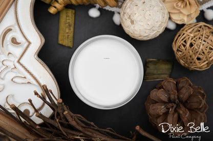 Fluff white color paint jar in a decorative container surrounded by natural elements on a dark surface with 'Dixie Belle Paint Company' branding.