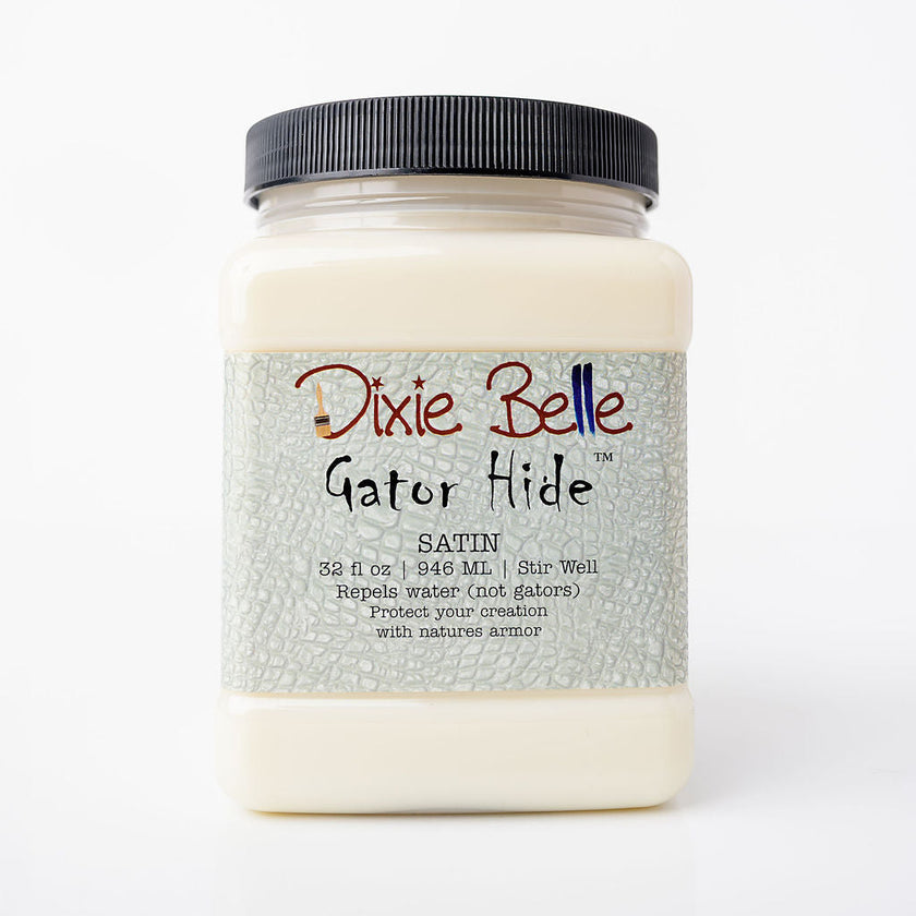 A jar of Dixie Belle Gator Hide Satin clear coat, featuring a black ribbed screw cap and a textured light gray label with red and black lettering, set against a plain white background.