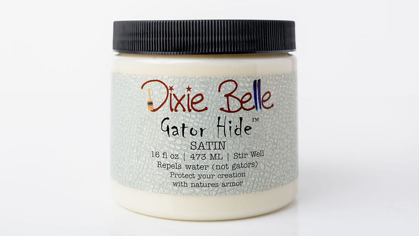 A jar of Dixie Belle Gator Hide SATIN clear coat, featuring a textured light gray label and a black ribbed screw cap, set against a plain white background.