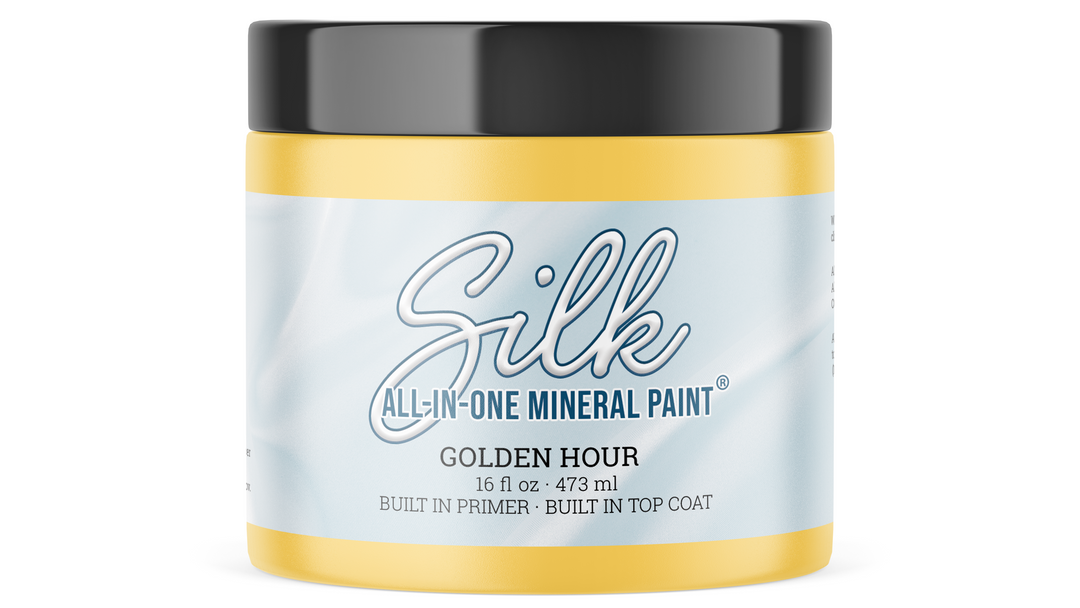 A jar of Silk All-In-One Mineral Paint in the Golden Hour color, featuring a light blue and white label with a black lid, set against a plain white background.