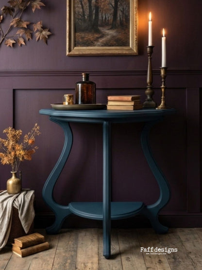 Blue side table with decorative items against a dark purple wall, featuring the brand 'Faff designs'.