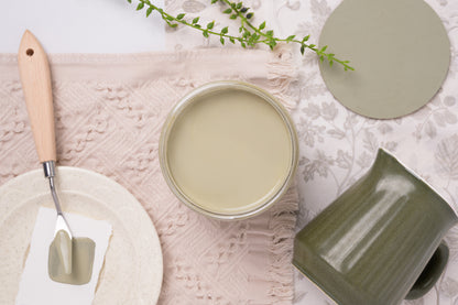 Jar of Highlands Paint on a textured surface with decorative elements