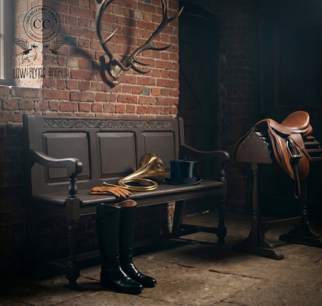 Vintage horn, boots, and saddle in a rustic room with brick wall and deer antlers.