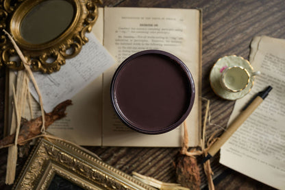 Jar of Dixie Belle Paint color Kindling on an open book with decorative elements