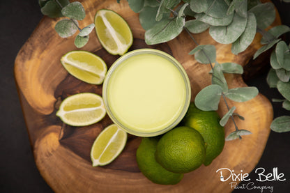 Wooden board with sliced limes and a container of green paint, featuring the Dixie Belle Paint Company logo.