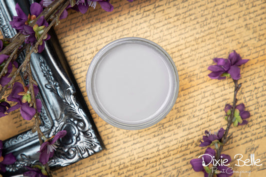 Dixie Belle Paint color Mason Dixon Gray on a textured surface with purple flowers