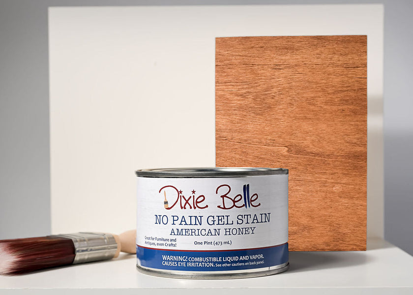 Can of Dixie Belle No Pain Gel Stain with a wooden sample and brush on a white surface