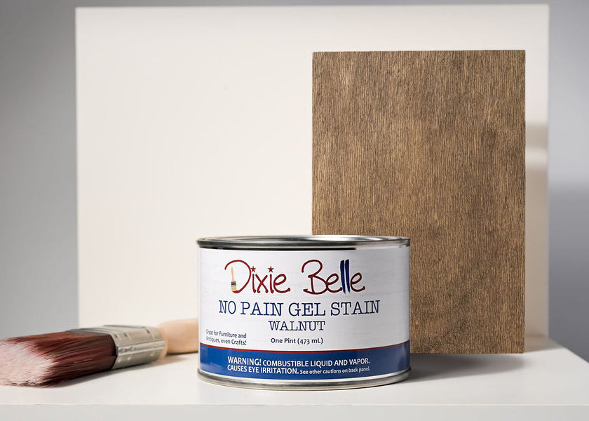 Dixie Belle No Pain Gel Stain can with a brush and wood sample on a neutral background