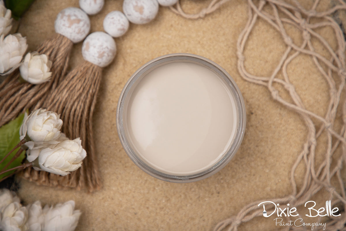 Dixie Belle Paint color Sand Bar surrounded by decorative elements on a textured surface