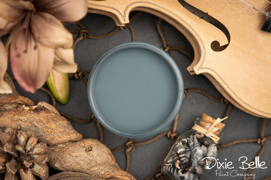 Dixie Belle paint color swatch labeled 'Stormy Seas' with floral and wooden elements.