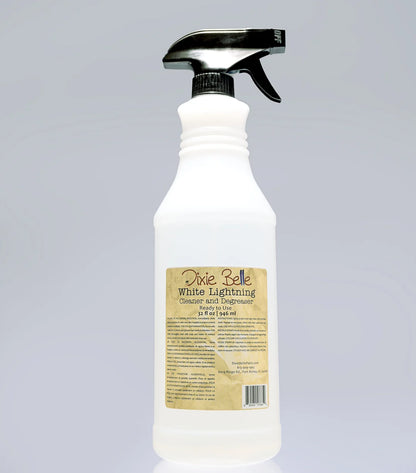 A white plastic spray bottle with a black trigger sprayer and a tan label reading Dixie Belle White Lighting Cleanse Acid Engraver, shown on a light gray background.