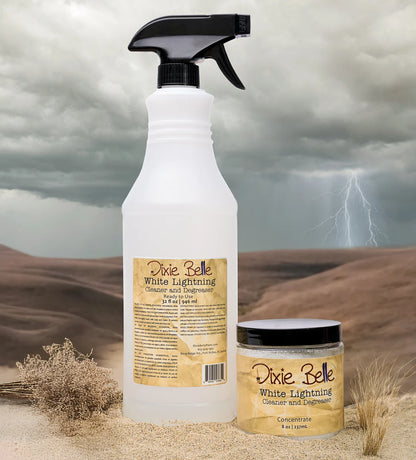 White spray bottle and jar of Dixie Belle White Lightning product on a desert background with stormy sky.