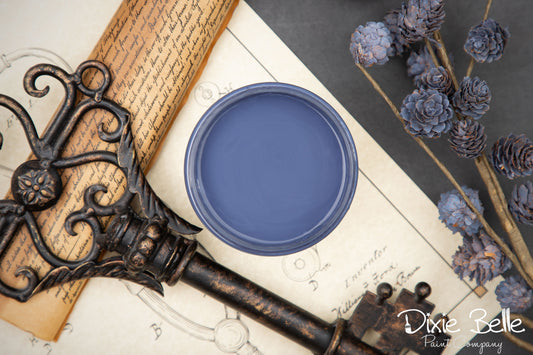 Blue paint swatch on a textured surface with decorative elements