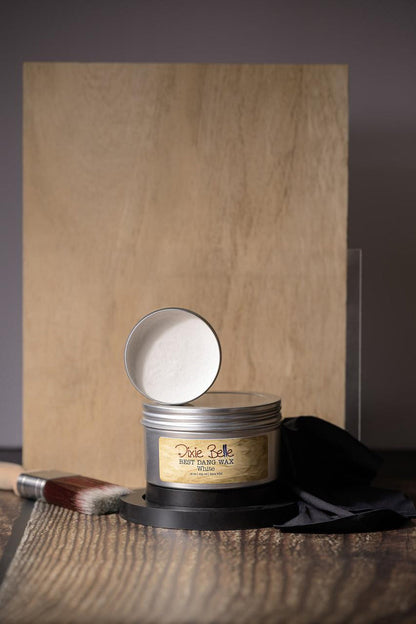 Metallic tin with a label on a wooden surface with a brown paper bag in the background.
