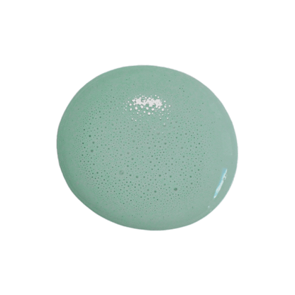A single round drop of Birdie milk paint with tiny air bubbles, shown on a solid white background.