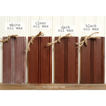 Four wooden planks with different oil wax finishes on a white background.