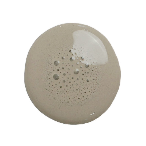 A drop of cobblestone milk paint on a white background
