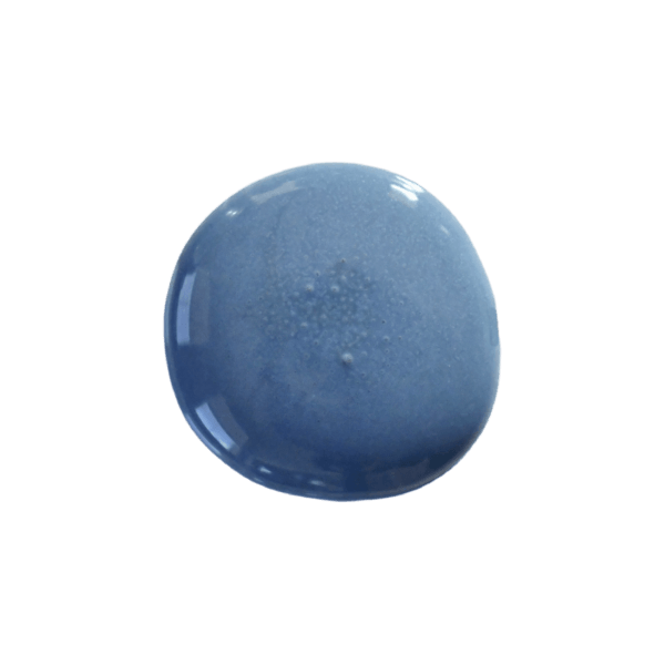 a drop of denim milk paint on a solid black background.
